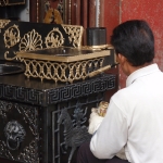 Tibetan man painting stove